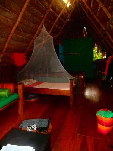a room with a bed in a tent at El Hotelito Perdido in Rio Dulce
