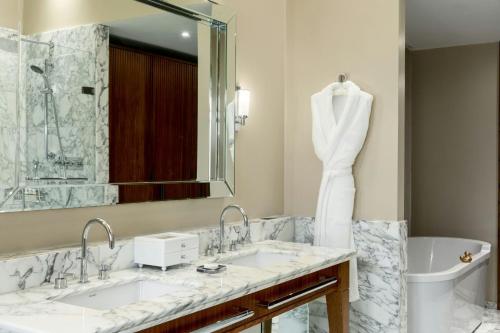 a bathroom with two sinks and a large mirror at St Pancras London, Autograph Collection in London