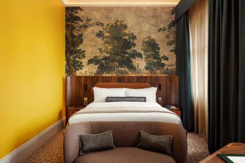 a bedroom with a large bed and a chair at St Pancras London, Autograph Collection in London