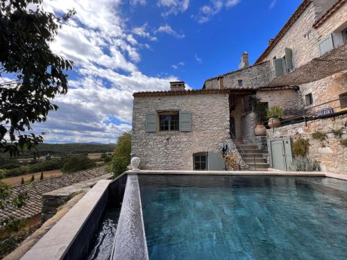 une maison avec piscine devant un immeuble dans l'établissement Oppida Lussan, à Lussan