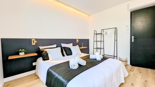 une chambre avec un grand lit avec des serviettes dessus dans l'établissement 151 - Terrasse & Jacuzzi, Rue Trivalle, Pied de la cité de Carcassonne - Climatisation, Netflix, Fibre, à Carcassonne