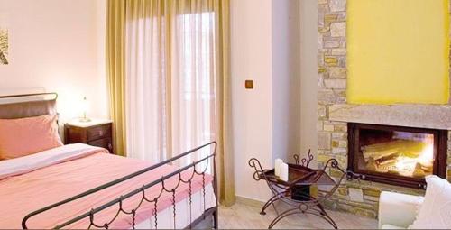 a bedroom with a bed and a fireplace at Evzin Hotel in Kato Loutraki