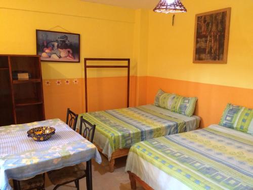 a room with two beds and a table in it at Hotel Las Salinas in Zihuatanejo