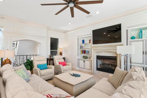 a living room with white furniture and a fireplace at Hog Heaven in Destin