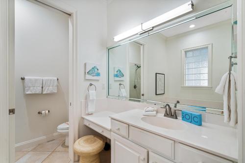 a white bathroom with a sink and a mirror at Hog Heaven in Destin