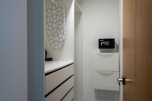 a kitchen with white cabinets and a clock on the wall at 9+Ocho Suites by Yellowkey in Santo Domingo