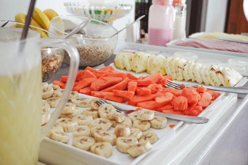 ジャボティカバルにあるHotel Estancia Santa Améliaの果物や野菜、飲み物が付いたビュッフェ