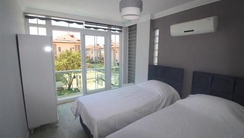 a bedroom with two beds and a large window at Oludeniz Villa with Private Pool in Fethiye