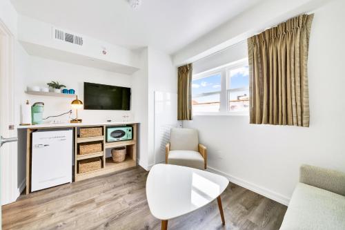 a white living room with a white table and chair at Madison Resort Wildwood Crest in Wildwood Crest