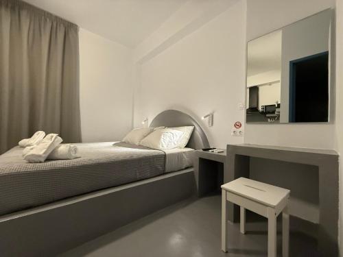 a bedroom with a bed with a mirror and a table at Urban Tinos in Tinos