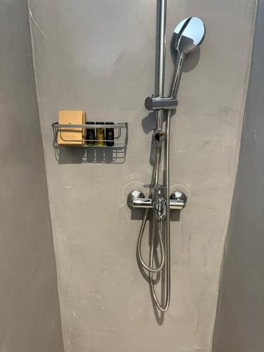 a shower with a shower head attached to a wall at Urban Tinos in Tinos