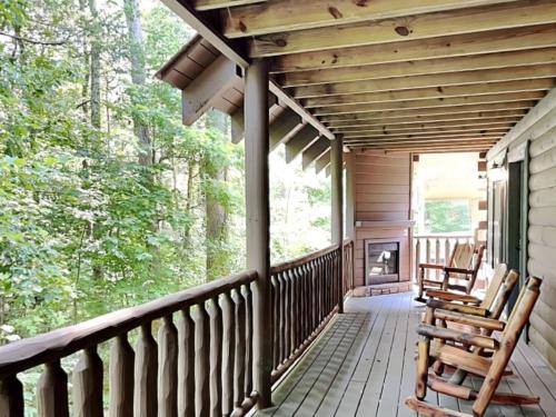 a porch of a cabin with two chairs and a fireplace at Peytons Hideaway in Gatlinburg