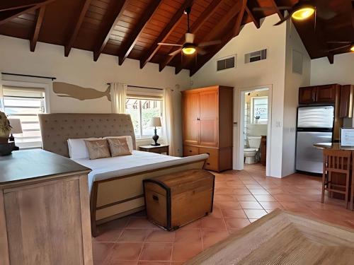 a bedroom with a large bed and a kitchen at Oceanfront Cottage with Pool in East End