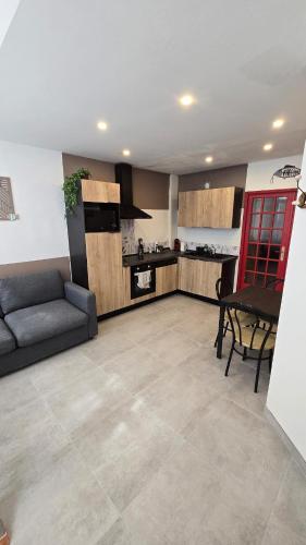 un salon avec un canapé et une cuisine dans l'établissement Le treport - centre - Plain-pied 1 chambre, au Tréport