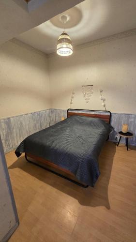 a bedroom with a bed with a black comforter at Le treport - centre - Plain-pied 1 chambre in Le Tréport
