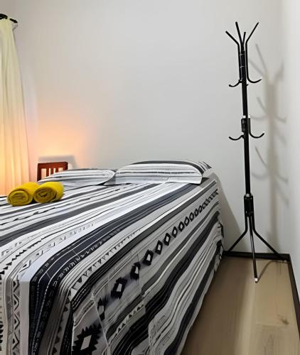 a bed with a black and white blanket on it at Excelente casa familiar no Centro FW in Pomerode