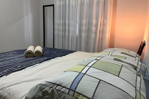 a bedroom with a bed with two shoes on it at Excelente casa familiar no Centro FW in Pomerode