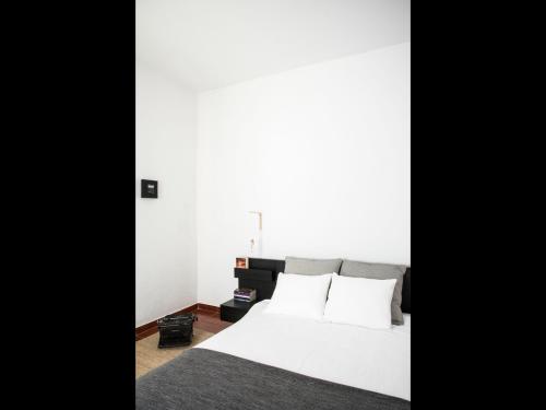 1 dormitorio con cama blanca y almohadas blancas en Nooks Apartment, en Sintra