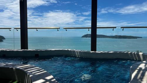 a swimming pool with a view of the ocean at Malibu Langkawi Private Pool Villa in Pantai Cenang