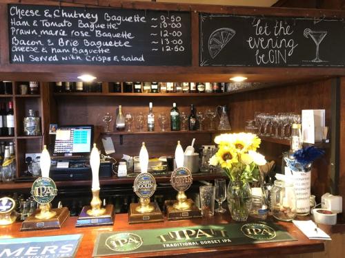 a bar with a chalkboard with a drink menu at The New Inn in Shipton Gorge