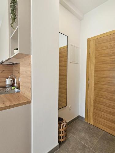 a kitchen with white walls and a wooden door at Apartments NIM in Jajce