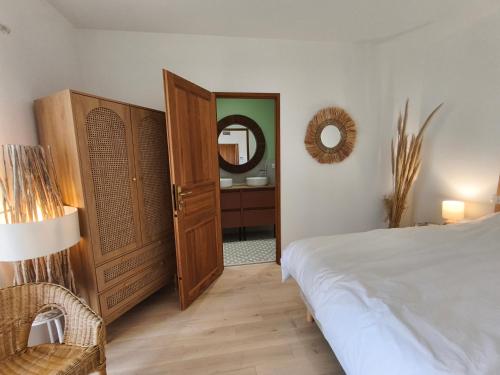 a bedroom with a large bed and a mirror at Chambre d'hôtes villa Adoya dans les remparts, piscine, ascenseur in Aigues-Mortes