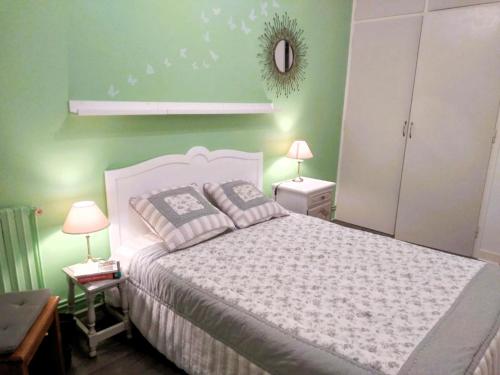 une chambre avec un lit blanc et des murs verts dans l'établissement LE ROCHEFORT - 2 chambres, à Les Sables-dʼOlonne