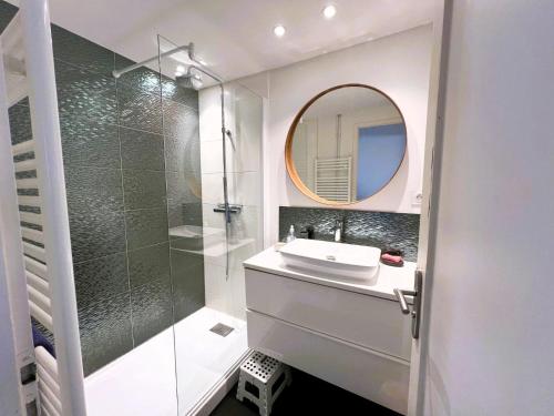 une salle de bain avec un lavabo et une douche avec un miroir dans l'établissement LE ROCHEFORT - 2 chambres, à Les Sables-dʼOlonne