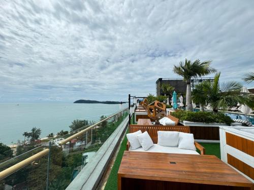 a balcony with a bench and a view of the ocean at Malibu Langkawi Private Pool Villa in Pantai Cenang