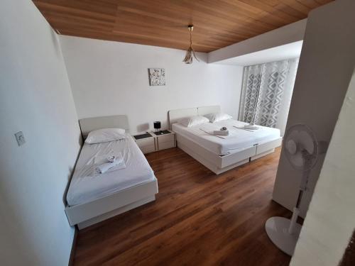 a small room with two beds and a window at Apartments Dalmacija in Podstrana