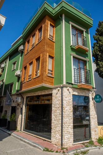 a green building with windows and a storefront at The Abies in Canakkale