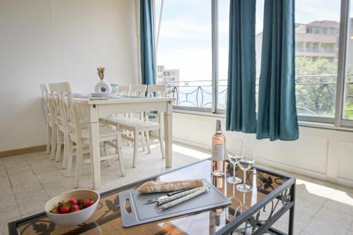 un salon avec une table avec une bouteille de vin dans l'établissement Jessica - Very luminous 1Br with loggia - by TGB, à Ajaccio