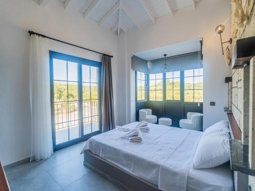 una camera da letto con un grande letto e due finestre di Blanco a Çeşme