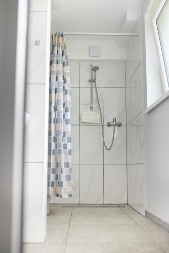 a bathroom with a shower with a shower curtain at Degučiai ,svečių namai in Šakiai