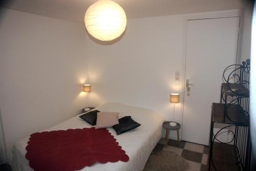 une chambre avec un lit avec une couverture rouge dessus dans l'établissement La Petite maison-Caluire 45 m2, à Rillieux-la-Pape