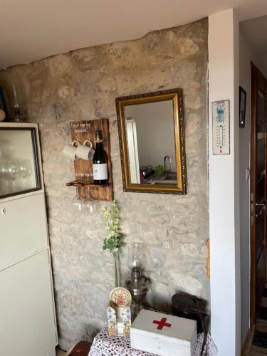 a mirror on the wall of a room with a table at Kisleshegy Vászoly Vendégház in Dörgicse