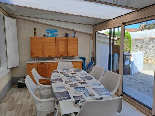 une salle à manger avec une table et des chaises et une cuisine dans l'établissement Location vacances, à La Bernerie-en-Retz