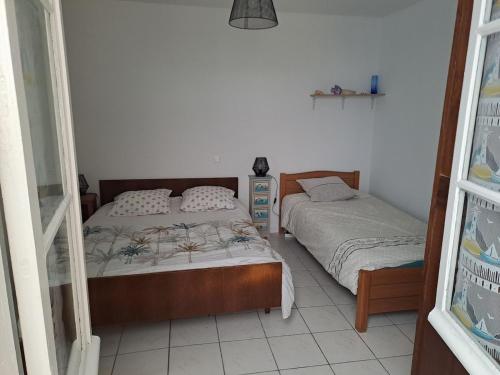 une chambre avec deux lits jumeaux et une fenêtre dans l'établissement Location vacances, à La Bernerie-en-Retz