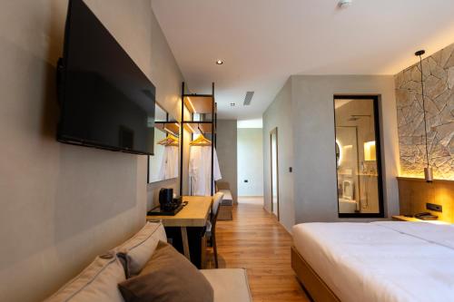 a hotel room with a bed and a tv on the wall at Montis Agroturizëm Hotel Spa in Kaninë