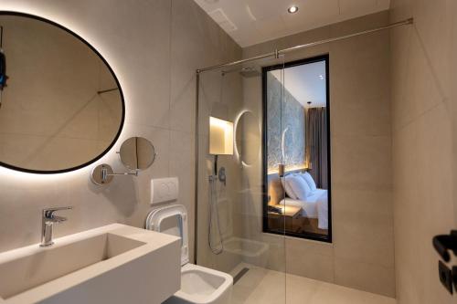 a bathroom with a sink and a toilet and a mirror at Montis Agroturizëm Hotel Spa in Kaninë