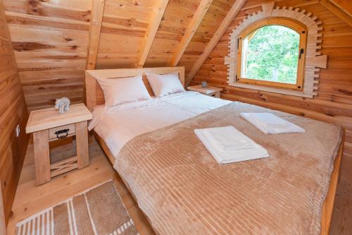 a bedroom with a bed in a log cabin at Wolf's PEAK in Kolašin