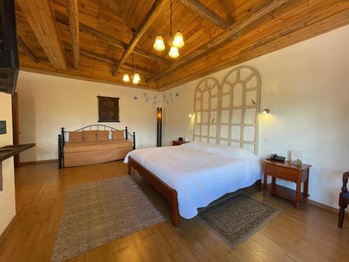a bedroom with a large bed and a wooden ceiling at Hacienda Hosteria Chorlavi in Ibarra