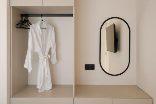 a bathroom with a mirror and a white robe at Anapnoe ikies Corfu Adults Friendly in Sfakerá