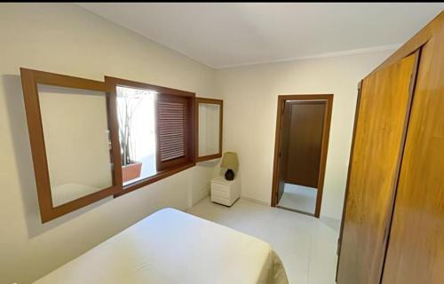 a bedroom with a bed and two windows at Casa ampla e confortável in Cotia
