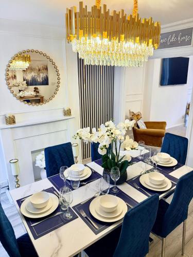 a dining room with a table with chairs and a chandelier at Vance Holiday Home in Blackpool