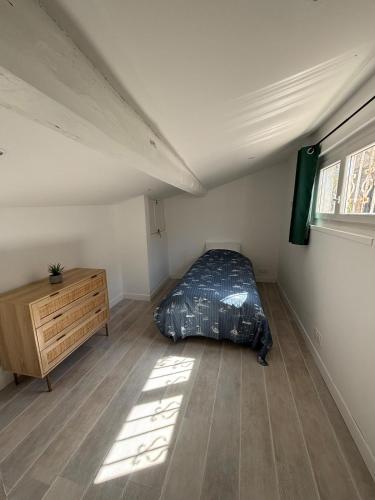une chambre avec un lit, une commode et une fenêtre dans l'établissement Maison 5p - 5mn plage - Cour privée - Climatisation, à Frontignan