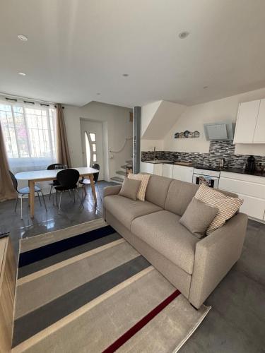 un salon avec un canapé et une table dans l'établissement Maison 5p - 5mn plage - Cour privée - Climatisation, à Frontignan