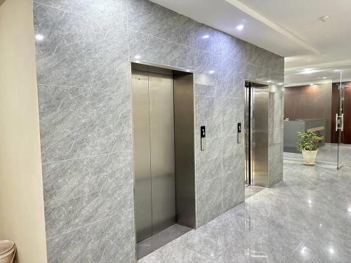 a lobby with a elevator in a building at Sitenest Suites in Islamabad