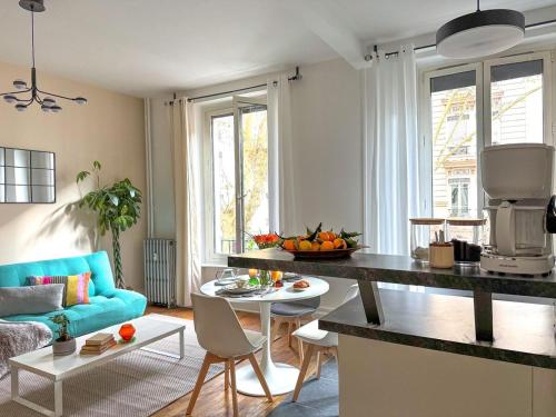 Il comprend une cuisine et un salon doté d'un canapé bleu. dans l'établissement Nid douillet au cœur de Lyon, à Lyon