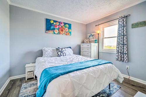 a small bedroom with a bed and a window at North Topsail Condo - Steps to Beach! in North Topsail Beach